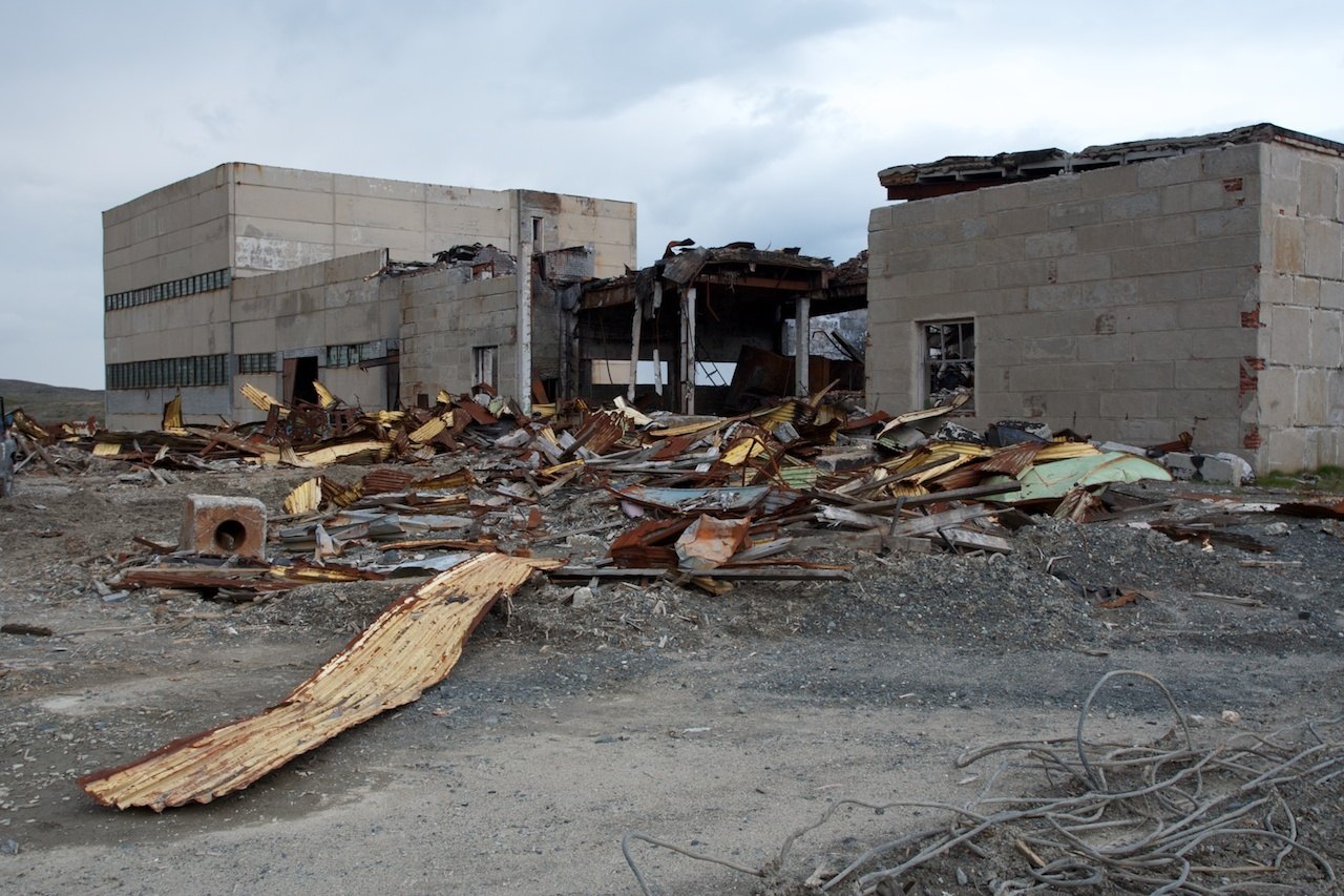 Damaged physical structure, surrounding area in disarray, abandoned